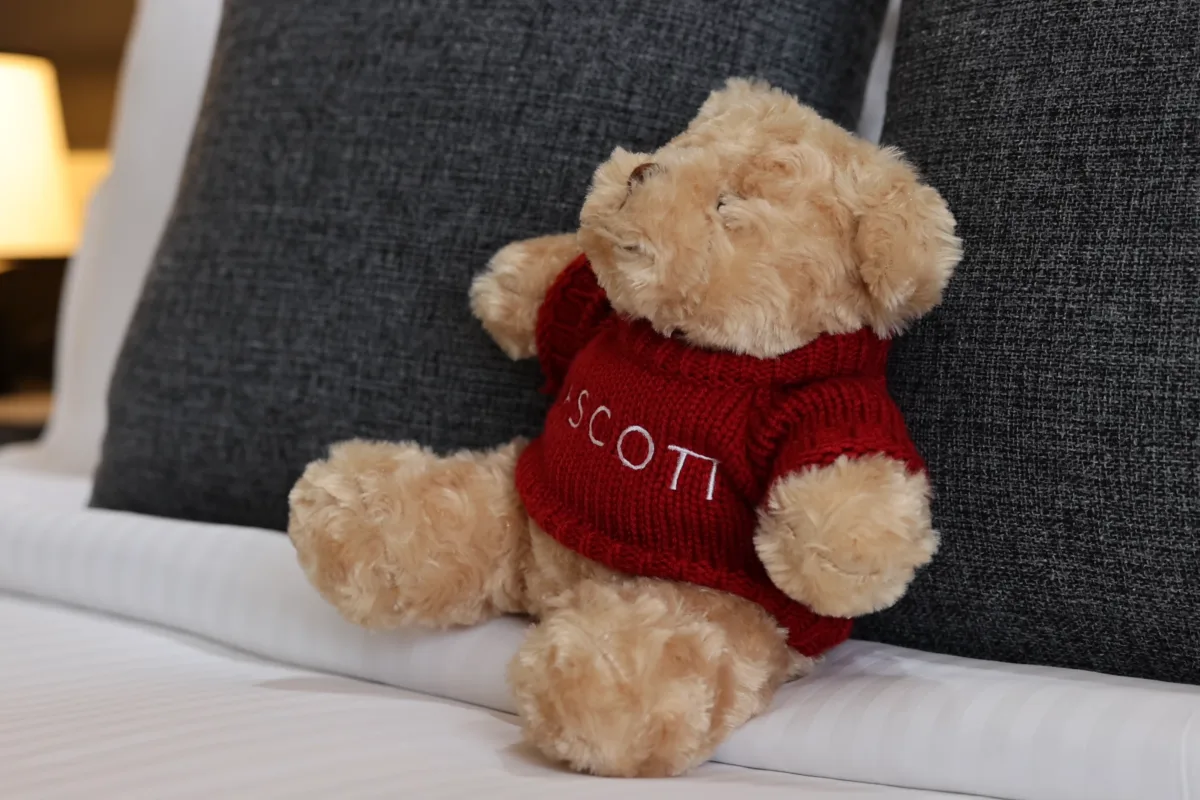 Ein Bett im Ascott Thonglor mit einem Teddybären im Ascott-Shirt