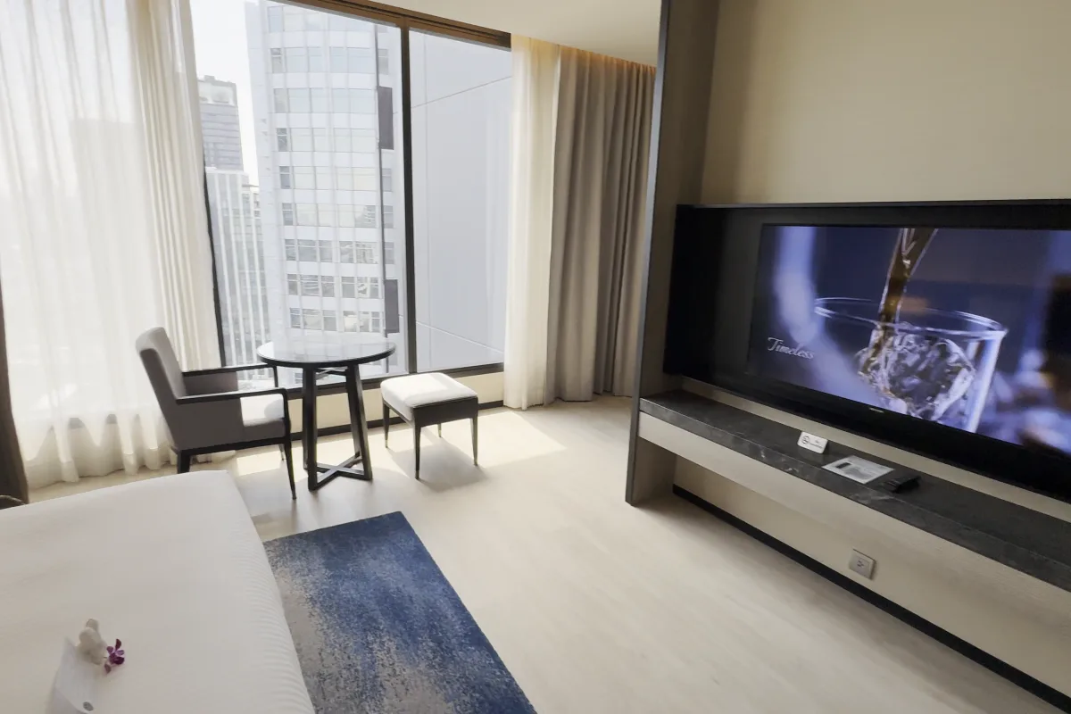 Wohnbereich mit Fernseher und Fenster im Studio Executive des Ascott Thonglor