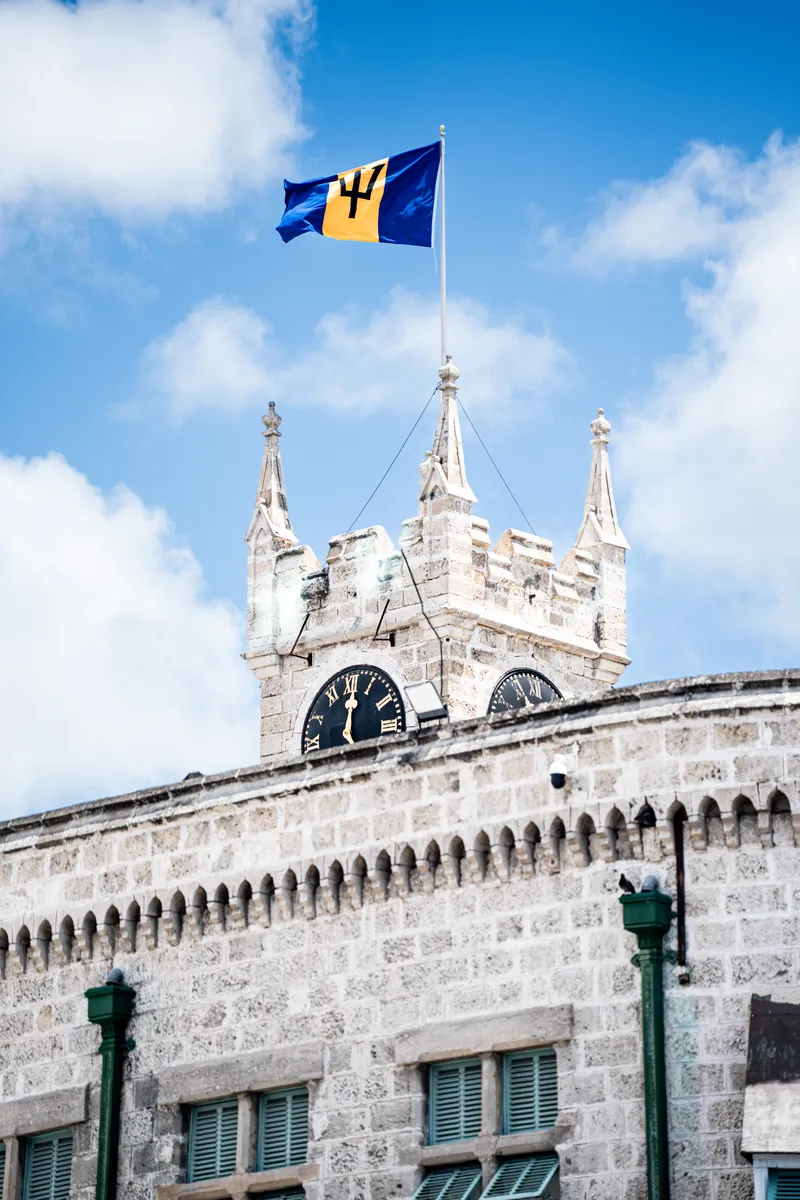 Neugotischer Turm der Parlamentsgebäude in Bridgetown mit Flagge von Barbados