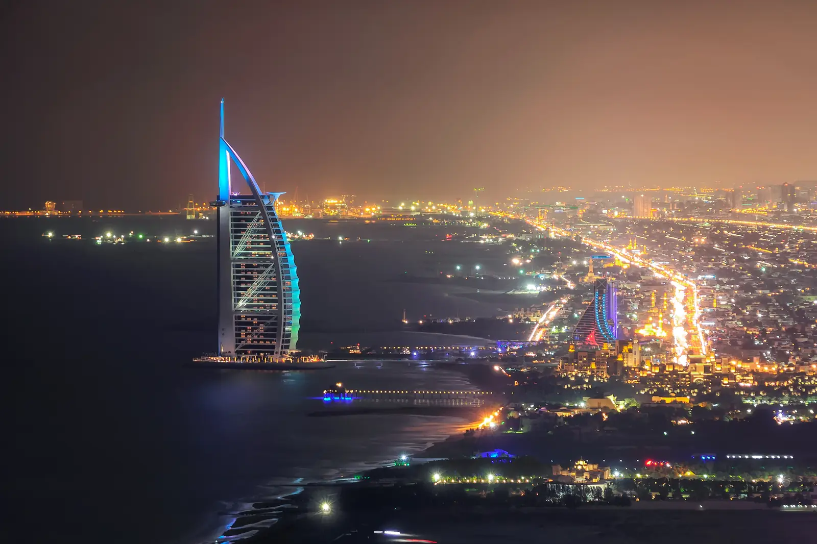 Das beleuchtete Burj Al Arab und die Küste von Jumeirah bei Nacht