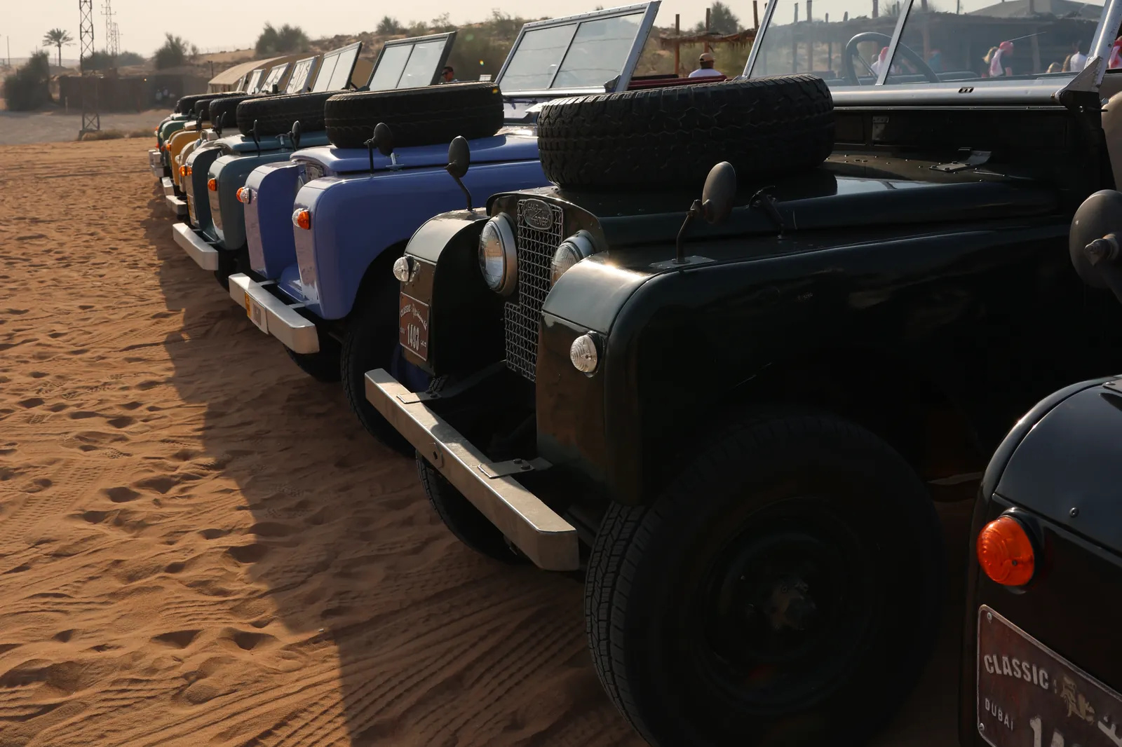 Oldtimer-Geländewagen im Sand vor einer Wüstensafari bei Dubai