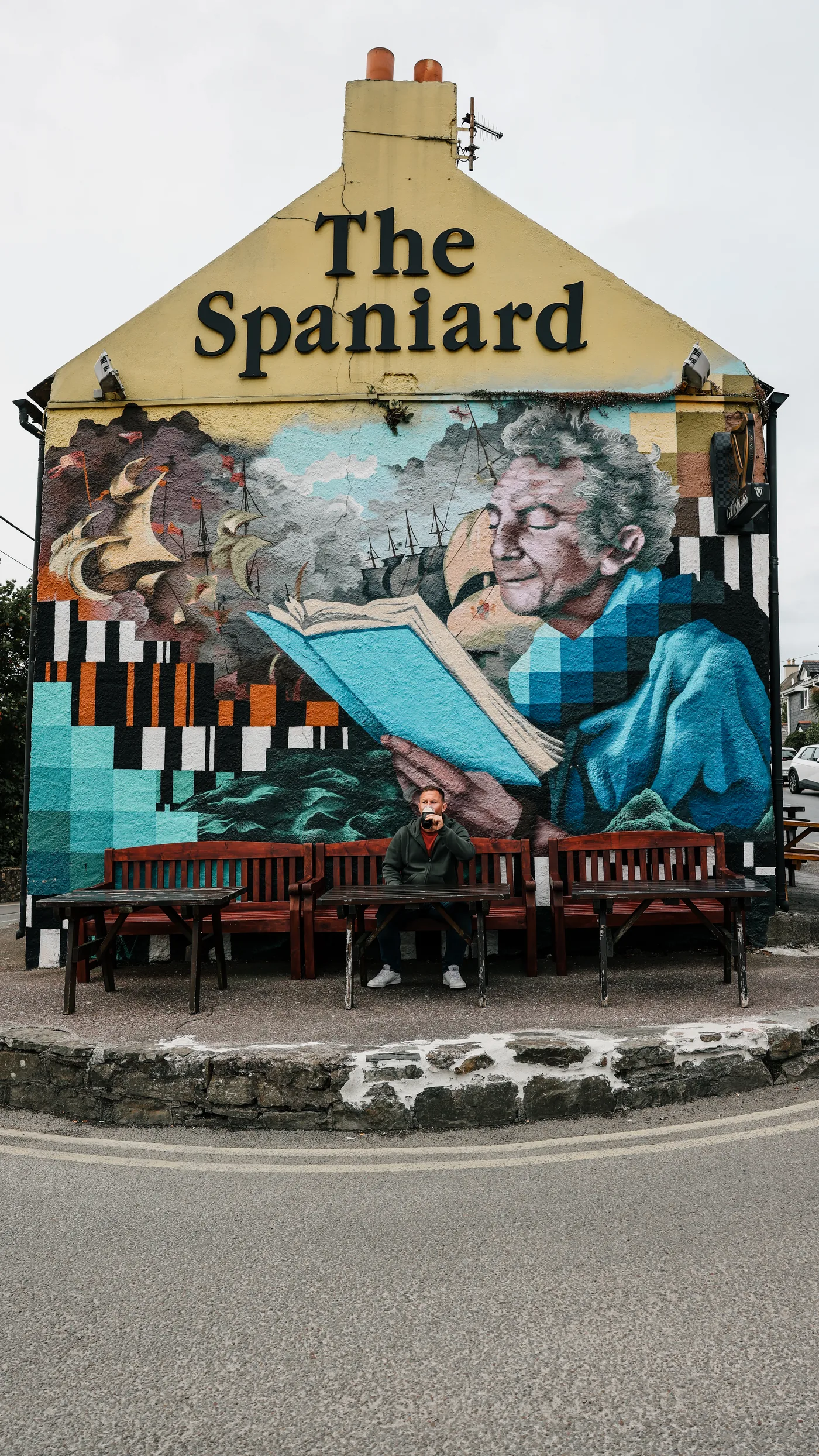 Benny mit einem Guinness vor dem Wandbild des Spaniard