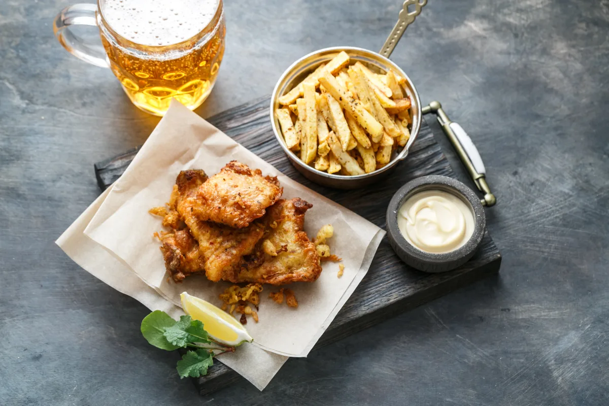 Fish and Chips mit Zitrone, Remoulade und einem Bier