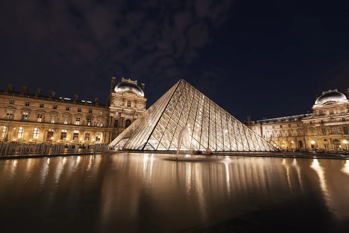 Die beleuchtete Glaspyramide im Hof des Louvre bei Nacht